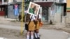 Estudiantes con una fotografía de Fidel Castro esperan en Buenaventura, Cuba, el 2 de diciembre de 2016, cuando una caravana con sus cenizas recorrió la isla hasta depositarlas en Santiago de Cuba.