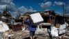 Un residente lleva a cuestas una lavadora dañada después del paso del huracán Ian en La Coloma, provincia de Pinar del Río, Cuba. (AFP/Yamil Lage).
