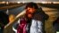 Una pareja de Cuba espera ser procesada para solicitar asilo después de cruzar la frontera, cerca de Yuma, Arizona. (AP/Gregory Bull/Archivo)