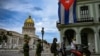 Oficiales de policía caminan cerca del Capitolio, sede de la Asamblea Nacional, en La Habana. (YAMIL LAGE / AFP)