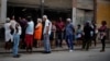 Cubanos hace fila para comprar pollo en una tienda subsidiada o "bodega" en La Habana.