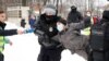 Un hombre vestido con un chaleco de prensa sostiene un micrófono mientras la policía lo detiene durante una manifestación en apoyo a Aleksei Navalny en San Petersburgo el 31 de enero de 2021.