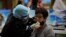 Una pasajera es examinada por coronavirus en el aeropuerto de La Habana. (YAMIL LAGE / AFP)