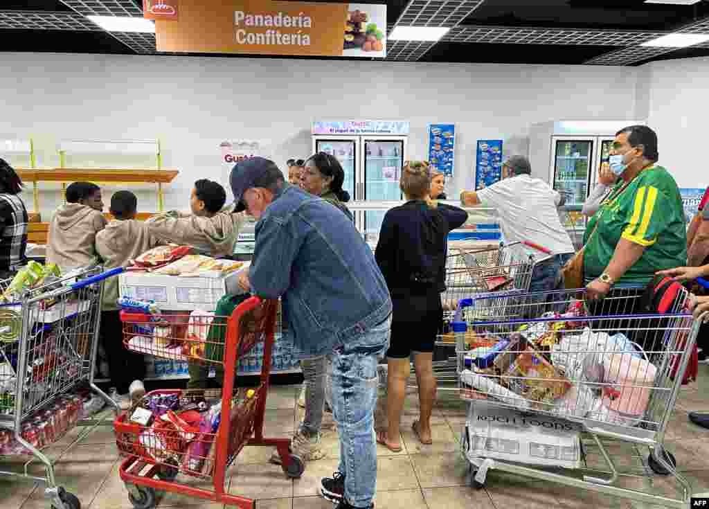 Clientes llenan sus carritos con productos de diversos tipos en el nuevo supermercado solo en dólares, en La Habana.
