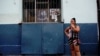 Una mujer fuma junto a una imagen de Fidel Castro. REUTERS/Alexandre Meneghini