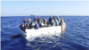 Diecisiete migrantes cubanos se sientan a bordo de un barco rústico aproximadamente a 54 millas al sur de Key West, Florida, el 18 de marzo de 2021. La tripulación del guardacostas Charles Sexton interceptó el barco rústico y repatrió a los 17 inmigrantes