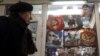 Un hombre observa varias sudaderas con la imagen del presidente de Rusia, Vladimir Putin, que se muestran en un escaparate de una tienda en Moscú, Rusia.