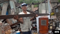 Un hombre rescata algunas pertenencias de su hogar, destruido por el paso del huracán "Sandy" en la ciudad de Santiago de Cuba.