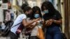 Cubanas usando el celular en las calles de La Habana. (Photo by YAMIL LAGE / AFP).