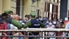 Cubanos se aglomeran en un mercado de La Habana, bajo la vigilancia de agentes de la policía, para comprar alimentos, el 12 de abril del 2020.