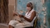 Una mujer lee el periódico en La Habana (Yamil Lage/AFP).