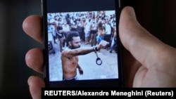 Un hombre que no quiso ser identificado muestra en su teléfono al rapero contestatario Maykel Castillo El Osorbo. (REUTERS/Alexandre Meneghini)