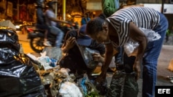 Varias personas buscan comida entre bolsas de basura el 31 de diciembre de 2016, en Caracas.