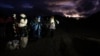 Migrantes solicitantes de asilo se envuelven en mantas para protegerse del viento y la lluvia mientras esperan a ser procesados tras cruzar la frontera con México, en Jacumba Hot Springs, California.
