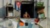 Un hombre con una máscara protectora desde su balcón en La Habana. (YAMIL LAGE / AFP)