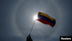 Un manifestante sostiene una bandera venezolana durante las protestas contra Nicolás Maduro este 1 de Mayo en Caracas.