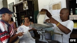 n bodeguero despacha a un anciano el arroz que se distribuye mediante la libreta de racionamiento.
