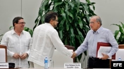El jefe negociador del Gobierno colombiano, Humberto de la Calle (d), saluda al segundo jefe de las FARC y líder de los delegados de la guerrilla en La Habana, Luciano Marín (c), alias "Iván Márquez.