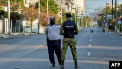 Oficiales de policía vigilan la entrada a un barrio del Vedado, en La Habana, cerrado por el coronavirus.