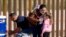 Una familia de inmigrantes cubanos tras cruzar la frontera a Estados Unidos, en Yuma, Arizona. RINGO CHIU / AFP/Archivo)