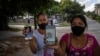 Foto Archivo. Madres de los presos del 11J, Eloy Bárbaro Cardoso y Dariel Cruz, muestran las fotografías de sus hijos detenidos. (Foto AP/Ramón Espinosa)