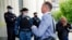 El abogado ruso Ivan Pavlov pasa junto a los agentes de policía para asistir a una sesión del tribunal después de hablar con los medios de comunicación en el Tribunal de Moscú en Moscú, Rusia, el 9 de junio de 2021. Foto: AP/Alexander Zemlianichenko.