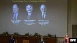 Una pantalla muestra las fotografías de los científicos estadounidenses (de izda a dcha) Randy W. Schekman y James E. Rothman así como la del alemán Thomas C. Südhof mientras se anuncian sus nombres como ganadores del Nobel de Medicina 2013.