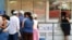 Varias personas hacen cola frente a una Casa de Cambio (CADECA).