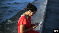Una joven se conecta a internet en el muro del Malecón, en La Habana.