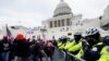 Partidarios de Trump intentan romper una barrera policial en el Capitolio, en Washington. (AP Photo/Julio Cortez)