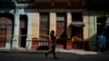 Una mujer pasa frente a varias casas en cuarentena por COVID-19 en un barrio de La Habana. REUTERS/Alexandre Meneghini
