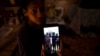 María Carla Milán Ramos muestra una foto en su teléfono de su esposo y sus hermanos, todos en prisión por participar en las protestas del 11 de julio del 2021.
